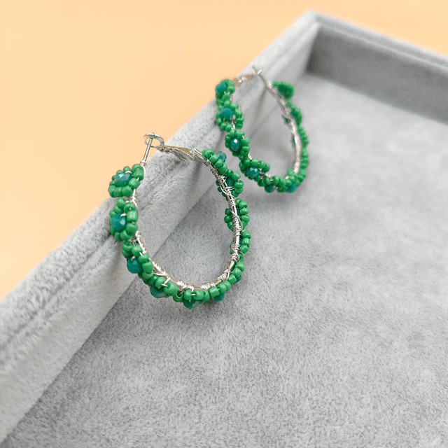 Boucles d’oreilles créoles argentées avec perles vertes en forme de petites fleurs