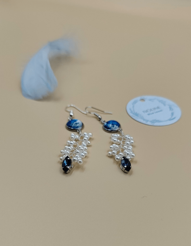 Boucles d’oreilles pendantes argentées avec cabochon abstrait bleu, perles blanche et strass bleue foncé
