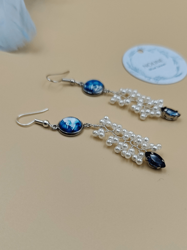 Boucles d’oreilles pendantes argentées avec cabochon abstrait bleu, perles blanche et strass bleue foncé