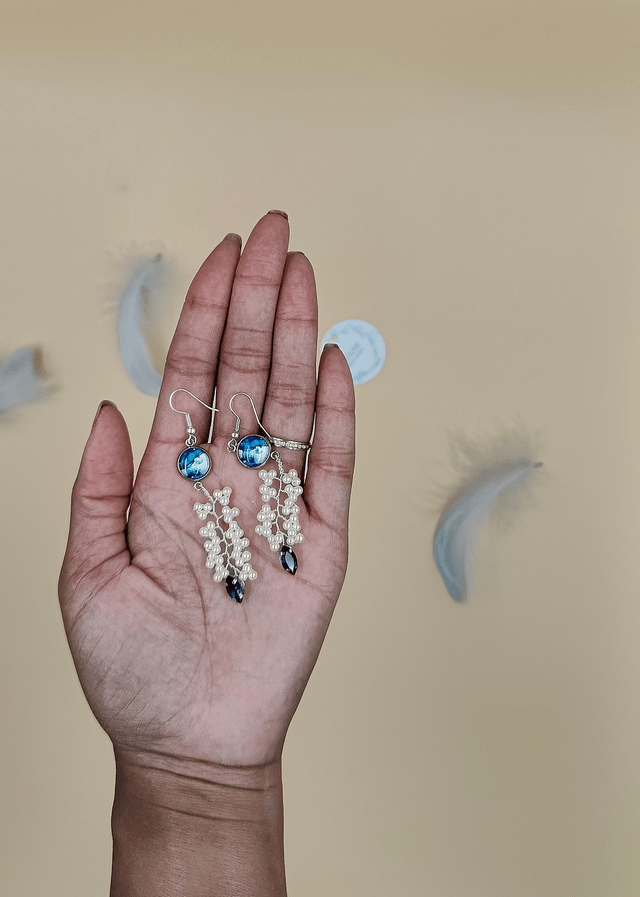 Boucles d’oreilles pendantes argentées avec cabochon abstrait bleu, perles blanche et strass bleue foncé